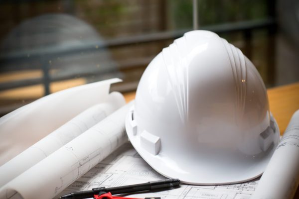 construction concept image helmet rolled blueprints on wooden boards in retro style.